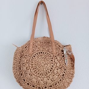 Bolso de rafia con abalorios colgando del bolso.