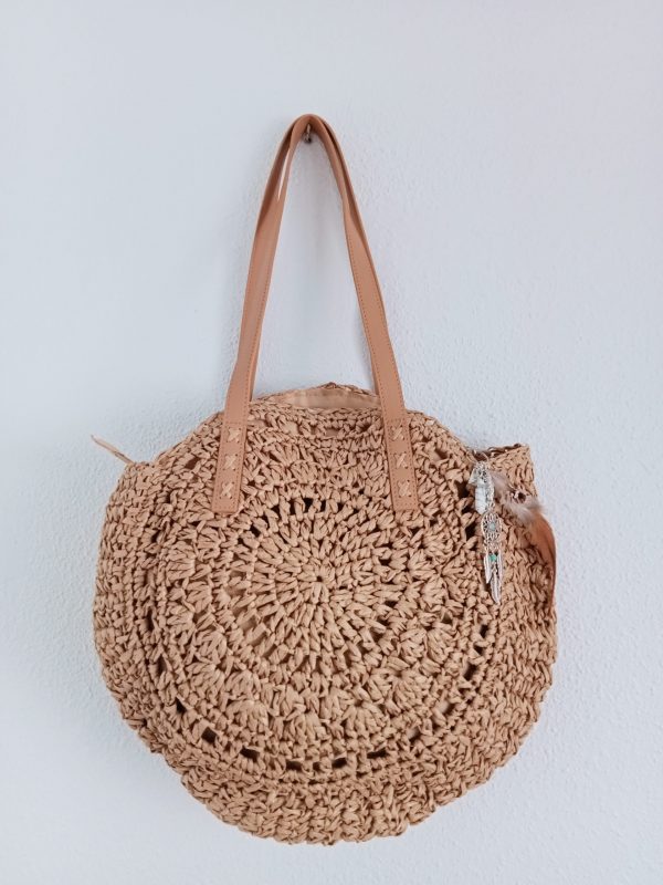 Bolso de rafia con abalorios colgando del bolso.